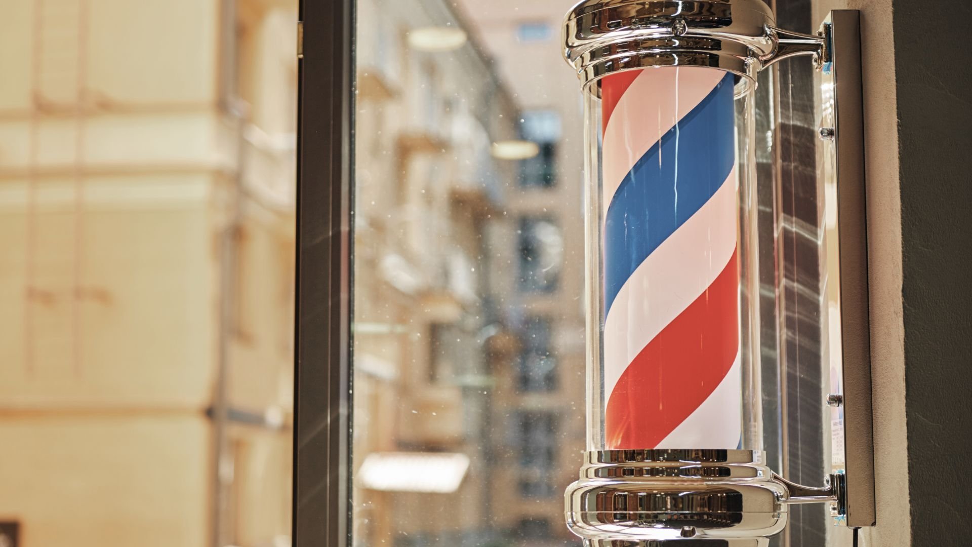 Classic red, white, and blue barber pole in shop window