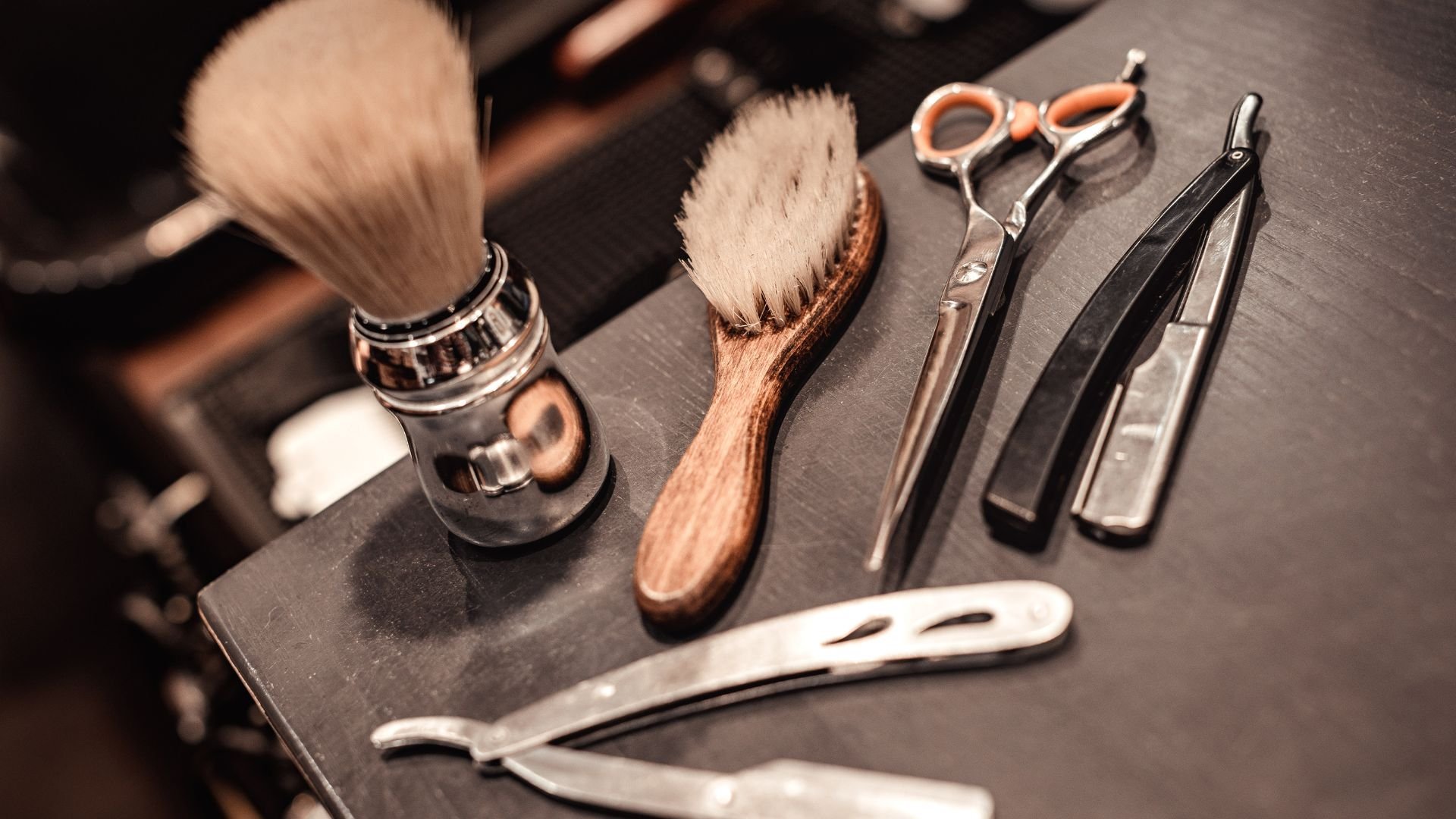 Vintage barbershop tools including shaving brush, scissors, and straight razors