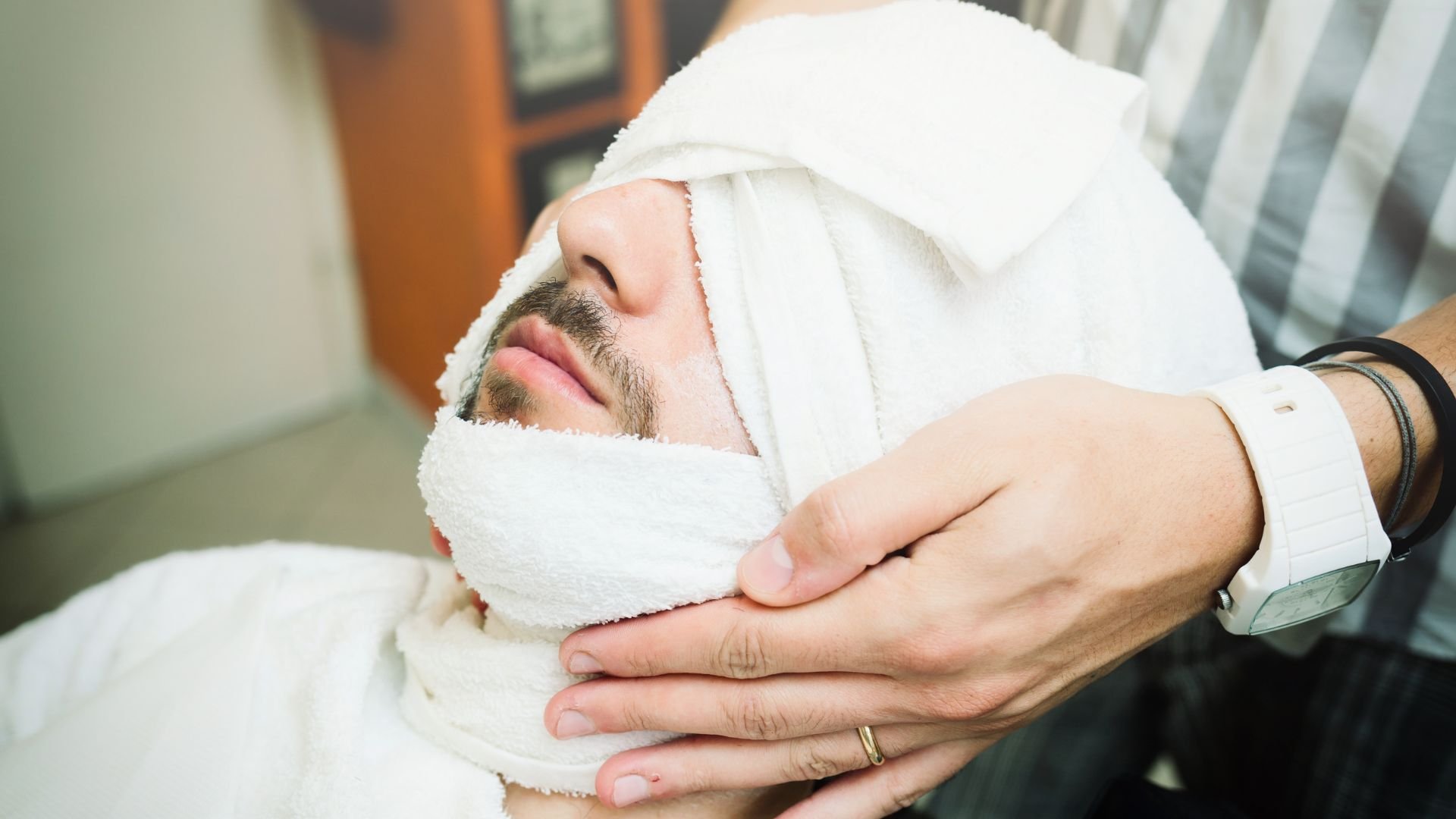 Person relaxing with white towel during spa treatment or massage